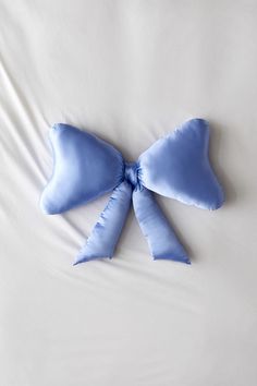 a blue bow laying on top of a white bed