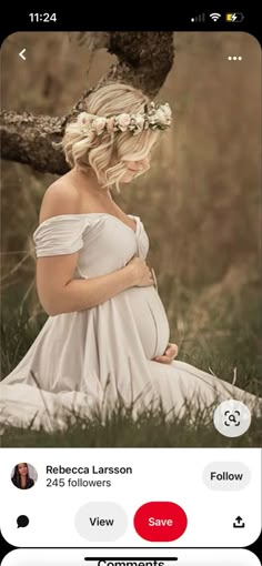 a pregnant woman sitting in the grass with her hands on her stomach wearing a flower crown