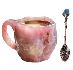 a pink marbled cup with a spoon next to it