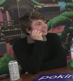 a man sitting at a table talking on the phone