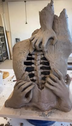 a sculpture is being made in the shape of a human head with hands on it