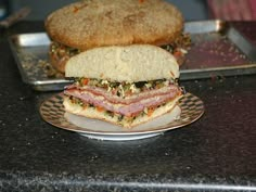 a sandwich sitting on top of a plate next to a muffin bun covered in toppings