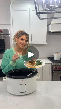 a woman is holding a plate with food in her hand while standing next to an instant pot