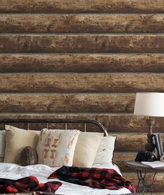 a bed sitting next to a lamp on top of a night stand in front of a wooden wall