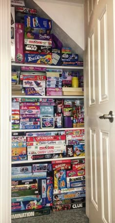 an open door leading to a room filled with toys and games on the shelves in front of it