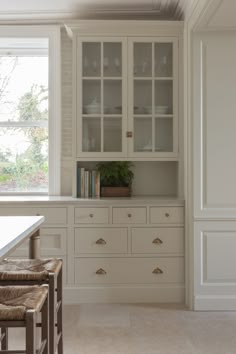 an empty kitchen with white cabinets and drawers