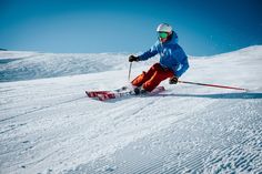 a person riding skis down a snow covered slope with ski poles in their hands