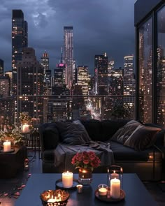 a living room filled with furniture and lit candles in front of a cityscape