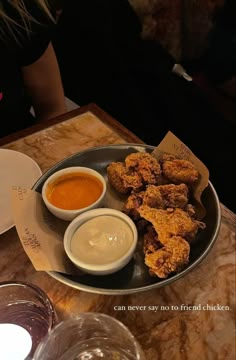 a plate filled with fried food and dipping sauces