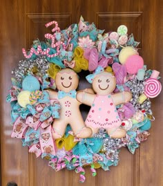 a wreath that has two teddy bears in it on the front door with candy and candies