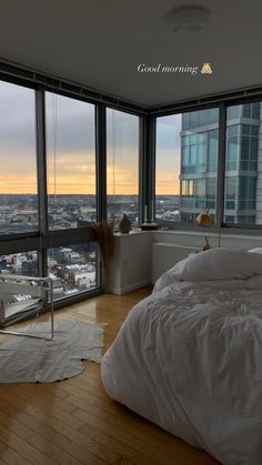 a bedroom with a large window and a view of the city from it's floor to ceiling windows