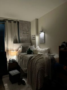 a bedroom with a bed, night stand and two lamps on either side of the bed