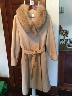 This is just a beautiful women's double breasted coat with a classic shape in a lovely soft beige colour. The coat, made by Sterling Stall, is made of a wool blend with a faux fur collar. It has a belt, cuffs on the sleeves,  two outer pockets and stitching detail around the yoke. It is fully lined. The measurements, taken with the coat lying flat, are: shoulder to shoulder, 17 inches; armpit to armpit, 19 1/2 inches; sleeves, 24 inches; overall length, 46 inches; sweep, 44 inches. About women's size small to small medium. In excellent condition. Winter Wool Fur Coat In Beige, Beige Wool Fur Coat For Winter, Winter Beige Wool Fur Coat, Beige Winter Fur Coat, Chic Beige Wool Fur Coat, Beige Winter Pea Coat For Formal Occasions, Formal Winter Beige Pea Coat, Formal Beige Pea Coat For Winter, Classic Cream Pea Coat For Winter