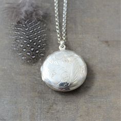 "This vintage sterling silver locket is engraved with a classic swirl design on the front and back. The large round locket opens to revealing two compartments awaiting your favorite photos. The pendant is suspended from a new sterling silver chain adorned with tiny amethyst stones at the clasp. Locket 30 mm Necklace 24\" (61cm) ✦All of our lockets ship with complimentary insurance✦ ✤Our entire selection of lockets can be found here✤ http://www.etsy.com/shop/LexiandGem?section_id=7506972" Elegant Pendant Necklaces With Engraving Option, Classic Oval Pendant Jewelry With Engraving Option, Wedding Pendant Jewelry With Engraving Option, Classic Wedding Necklaces With Engraving Option, Classic Wedding Necklace With Engraving Option, Engraved Locket Necklace With Round Pendant, Classic White Gold Locket Necklaces, Silver Heirloom Oval Necklace, Vintage White Gold Jewelry With Engraving Option