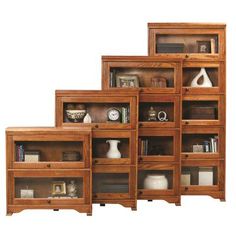 four wooden bookshelves with glass doors on each side and shelves in the middle