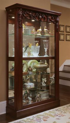 a wooden display case filled with glass and figurines