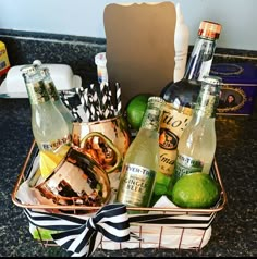 a basket filled with alcohol and limes on top of a counter