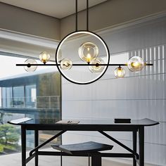 a dining room with a table and some lights hanging from it's center point