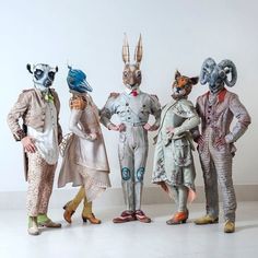 four people dressed up in costumes with animals on their heads and legs, standing next to each other