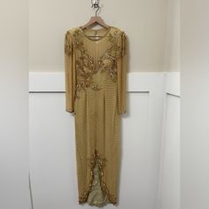 Preowned, Vintage Formal Dress By A.J. Bari In The Size 6. The Material Is 100% Silk. Fitted. Long Sleeve. Front Bottom Split. Side Bottom Splits. Beaded Throughout. Back Peep Hole Accent With Clasp Closure. Back Zipper Closure. *A Classic. Chic. Classy. Stunning. Unique* *Ideal For A Wedding. An Elegant Party/Dance.* *Small Flaw On Upper Left Shoulder. Please Refer To Picture With The White “X”* Thank You For Shopping At Charms Kloset, I Truly Appreciate It. Please Let Me Know If You Have Any Questions! Embellished Gown With Fitted Bodice For Banquet, Fitted Hand Embellished Evening Dress For Wedding, Embellished Gown With Fitted Bodice For Banquets, Festive Embellished Gala Gown, Embellished Fitted Evening Dress For Mother Of The Bride, Embellished Gown With Fitted Bodice For Party Season, Party Season Embellished Gown With Fitted Bodice, Glamorous Wedding Dress With Zari Work, Hand Embellished Maxi Evening Dress For Gala