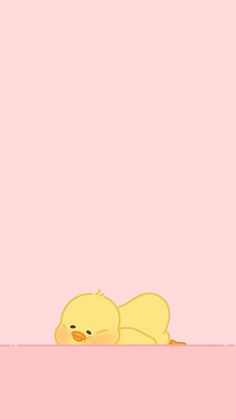 a yellow duck laying on top of a pink surface