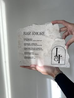 a person holding up a piece of paper that says bar amore