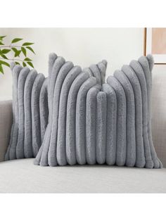 two gray pillows sitting on top of a couch