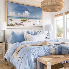 a bed with blue sheets and pillows in a bedroom next to a painting on the wall