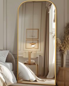 a large gold framed mirror sitting on top of a bed