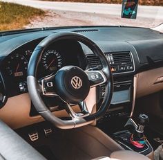 the interior of a car with steering wheel and dashboard