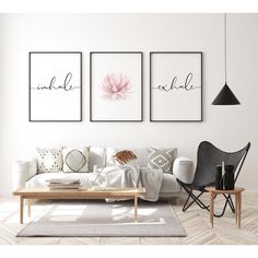 three black and white prints on the wall above a couch in a living room with two chairs