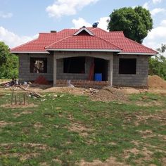 a house under construction in the middle of a field with grass and dirt around it