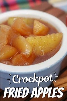 apples and cinnamon sticks sit in a bowl on a table next to an apple cider