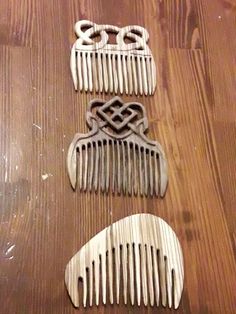 three combs sitting on top of a wooden table next to each other and one is shaped like an owl