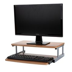 a computer monitor sitting on top of a wooden desk next to a keyboard and mouse