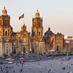 an aerial view of the plaza in mexico with many people walking around and cars parked on the street