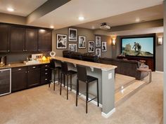 a home theater room with bar seating and pictures on the wall behind the barstools