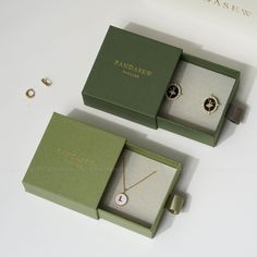 two jewelry boxes with rings and necklaces in them