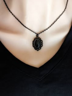 "This Obsidian necklace features a richly polished black Obsidian cabochon set in an elegant oval pendant. The vintage-inspired pendant has a lovely lace-like design around the perimeter. The combination of the pendant and inky black stone is beautiful. Available in three finishes: silver, bronze, or black. All pendants are plated brass. Chains are plated brass except for the silver version which is stainless steel.  For those that follow Crystal beliefs: Obsidian is believed to be truth-enhanci Black Stone Necklace, Black Obsidian Necklace, Jewelry Goth, Obsidian Necklace, Victorian Pendants, Necklace Gothic, Vintage Inspired Jewelry, Witchy Jewelry, Jewelry Black