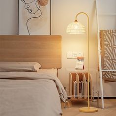 a bedroom with a bed, lamp and pictures on the wall above it in an apartment