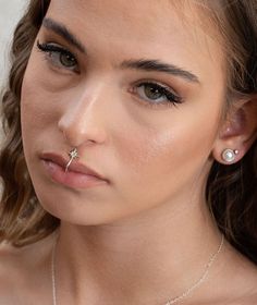 a woman wearing a nose piercing with pearls