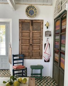 an image of a room with chairs and rugs on the floor in front of a wooden door