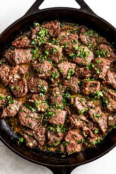 a skillet filled with meat and vegetables