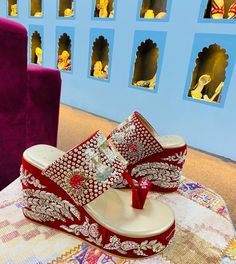 a pair of red and white shoes sitting on top of a rug next to purple couches