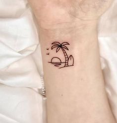 a small palm tree tattoo on the wrist