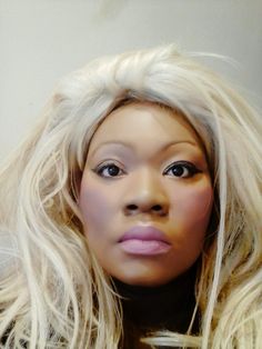 a close up of a mannequin head with long blonde hair and pink lipstick