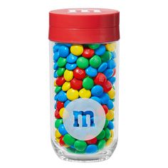 a glass jar filled with m and m candies