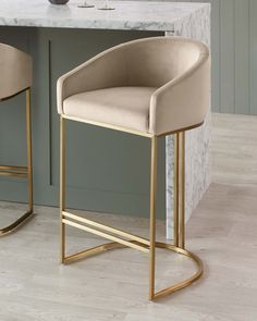 two modern bar stools in front of a marble counter