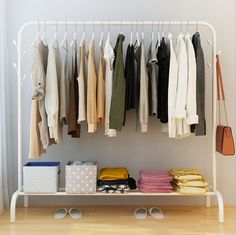 an organized closet with clothes hanging on the rack and other items in front of it