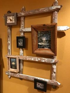 an old wooden frame is hanging on the wall with pictures and other things around it